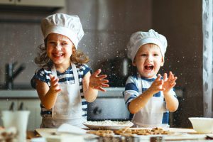 happy family  funny kids are preparing the dough, bake cookies in the kitchen